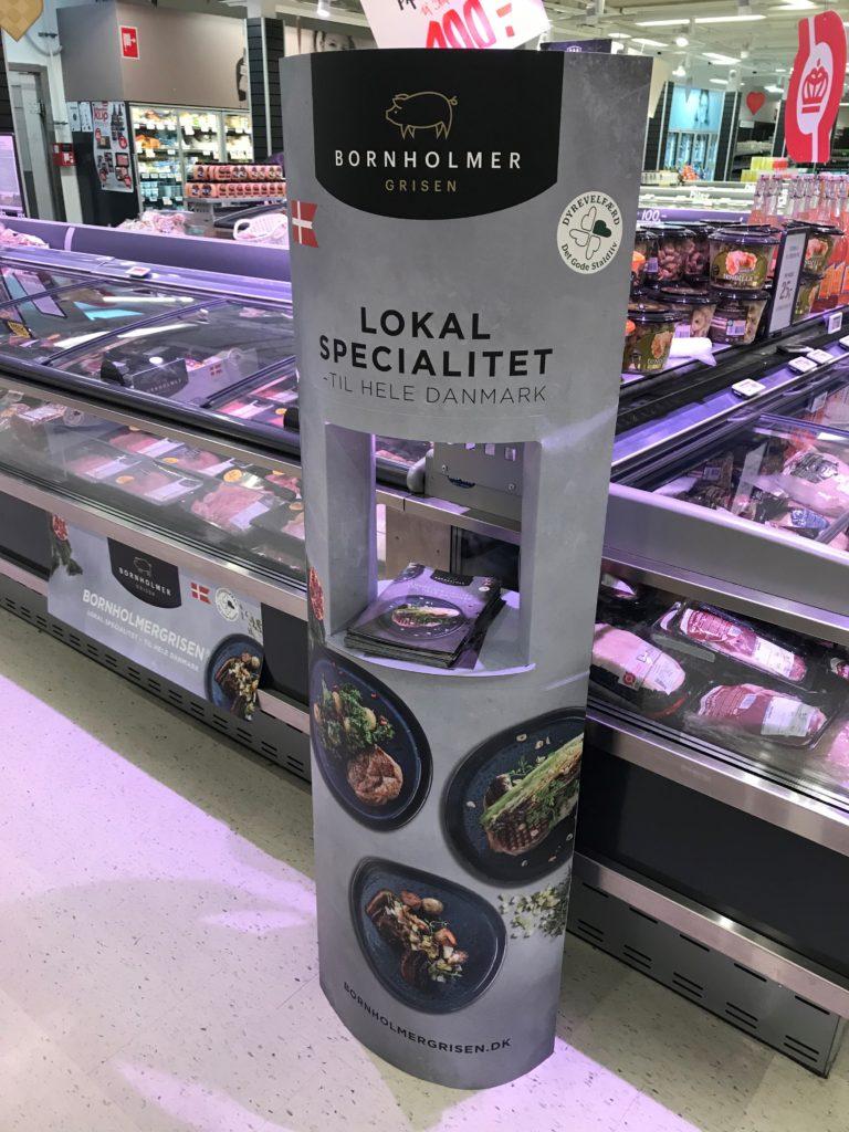 Lokal specialitet fra Bønholmer, præsenteret i supermarked med billeder af retter og dansk flag.