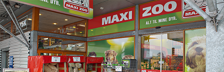 Facade af MAXI ZOO butik med dyreforsyninger og billeder af hunde og katte.