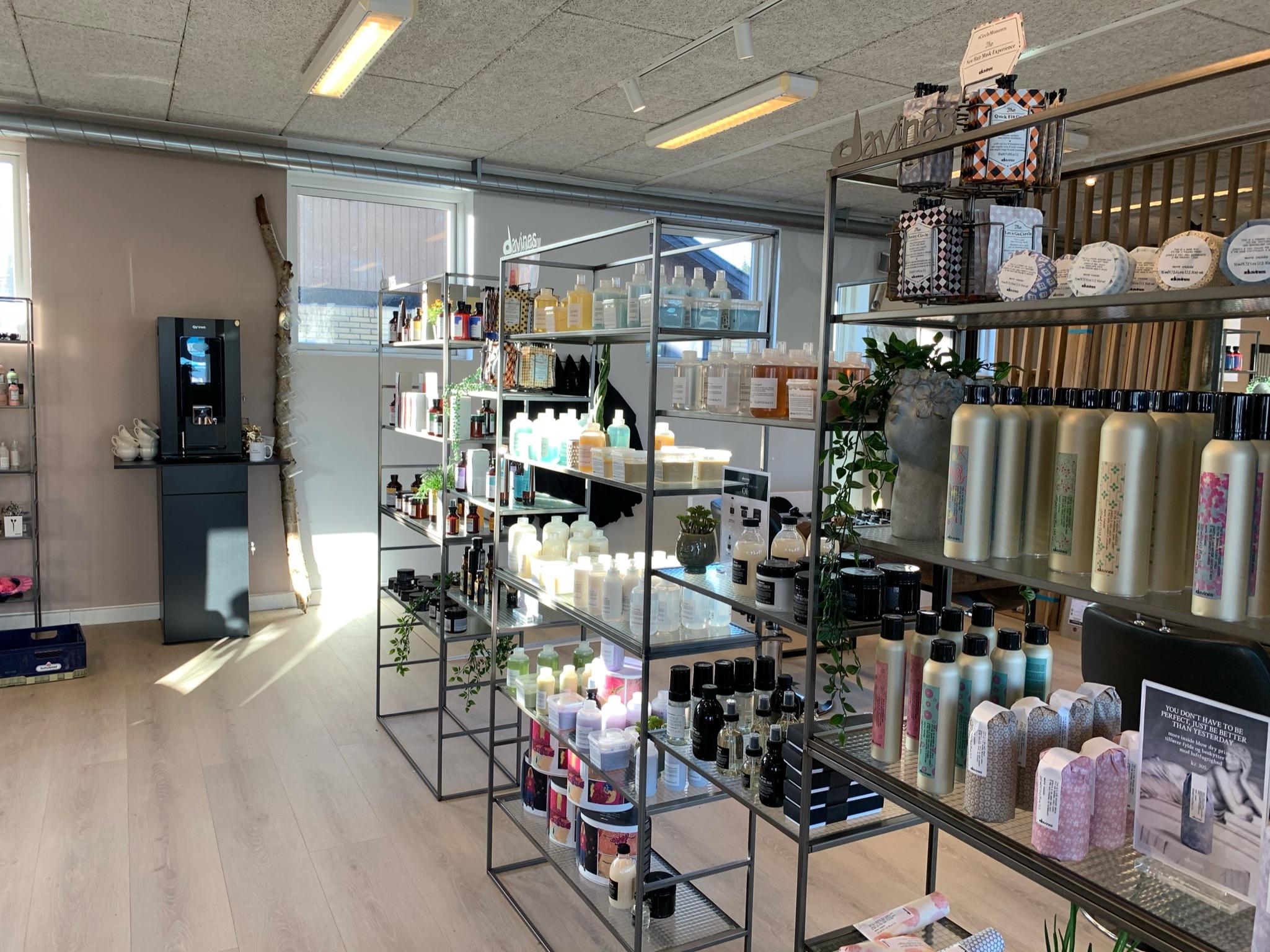En moderne butik med hylder fyldt med skønhedsprodukter og en vanddispenser i baggrunden.