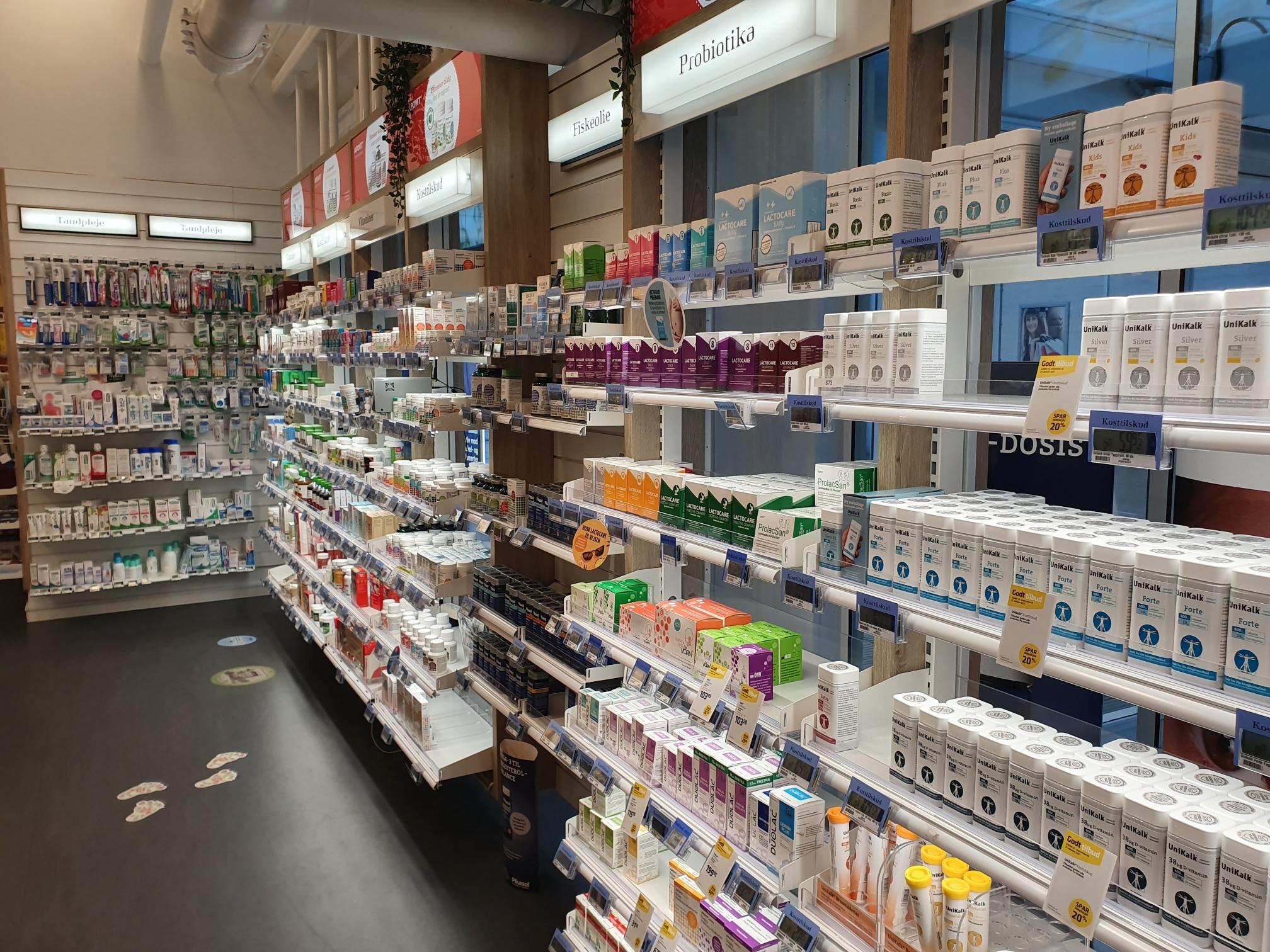 Hylder med forskellige sundhedsprodukter og kosmetik i en butik, organiseret i rækker med farverige emballager.