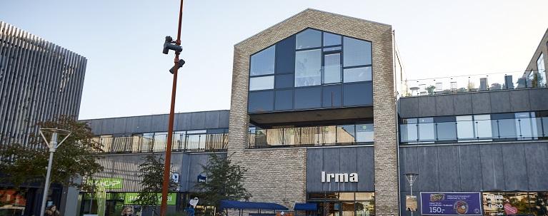 En moderne Irma-butik med en karakteristisk facade og store vinduer i en bymiljø.