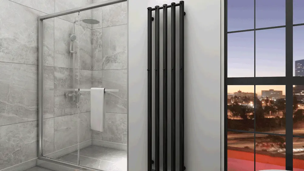 Moderne badeværelse med glasbrusekabine, sort radiator og vindue med udsigt over byen ved solnedgang.