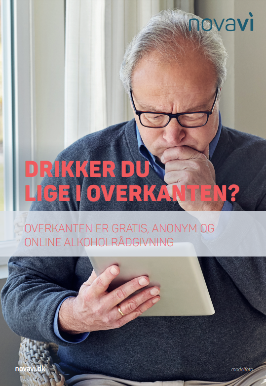 Mand med briller, der læser en brochure om anonym online rådgivning om alkoholforbrug.