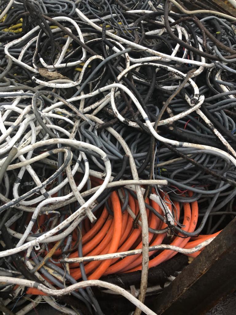 En bunke af sammenfiltrede elektriske kabler i forskellige farver, herunder sort, hvid og orange.