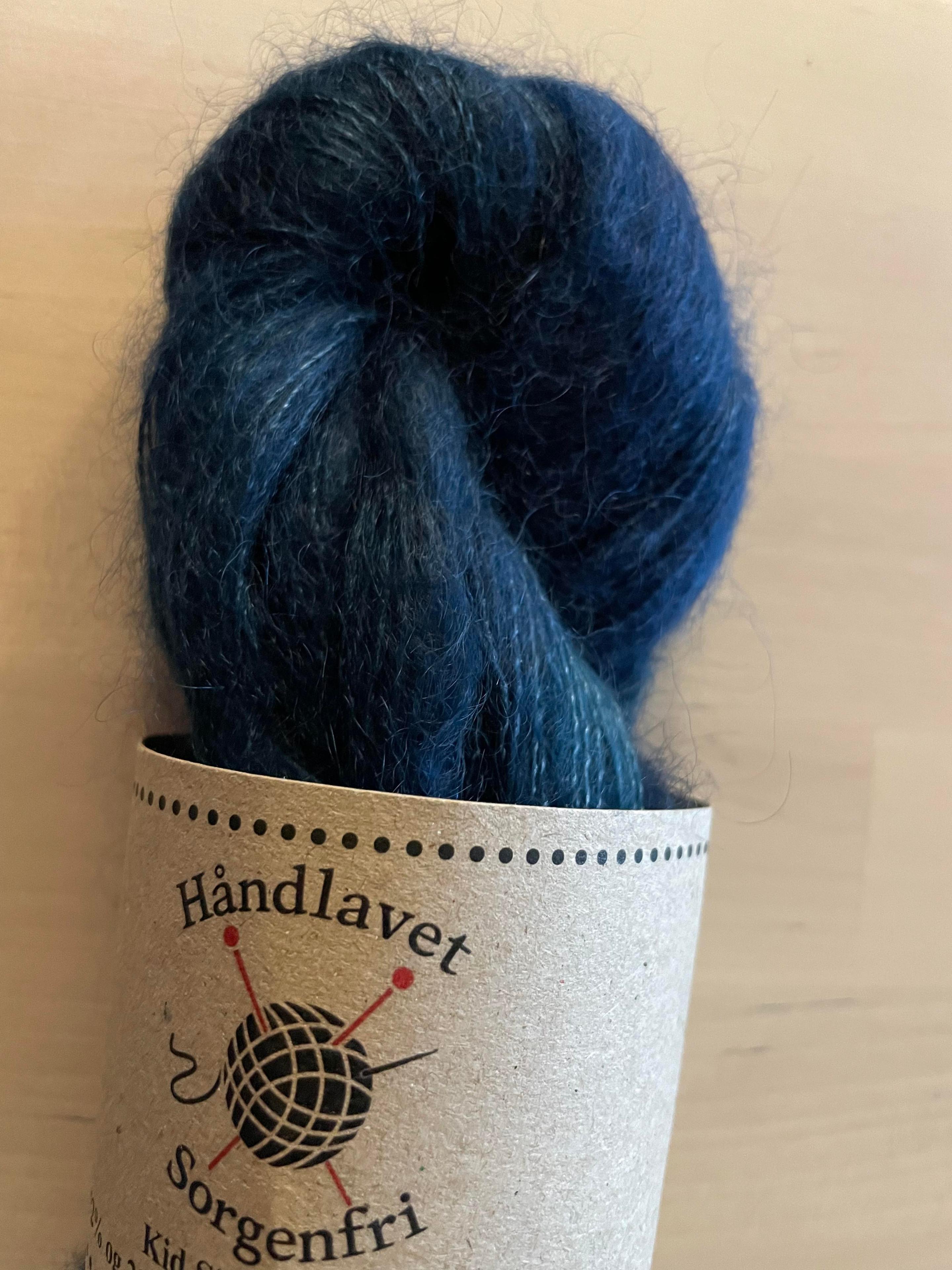 Håndlavet garn i mørkeblå nuancer med et etikette fra Sorgenfri.