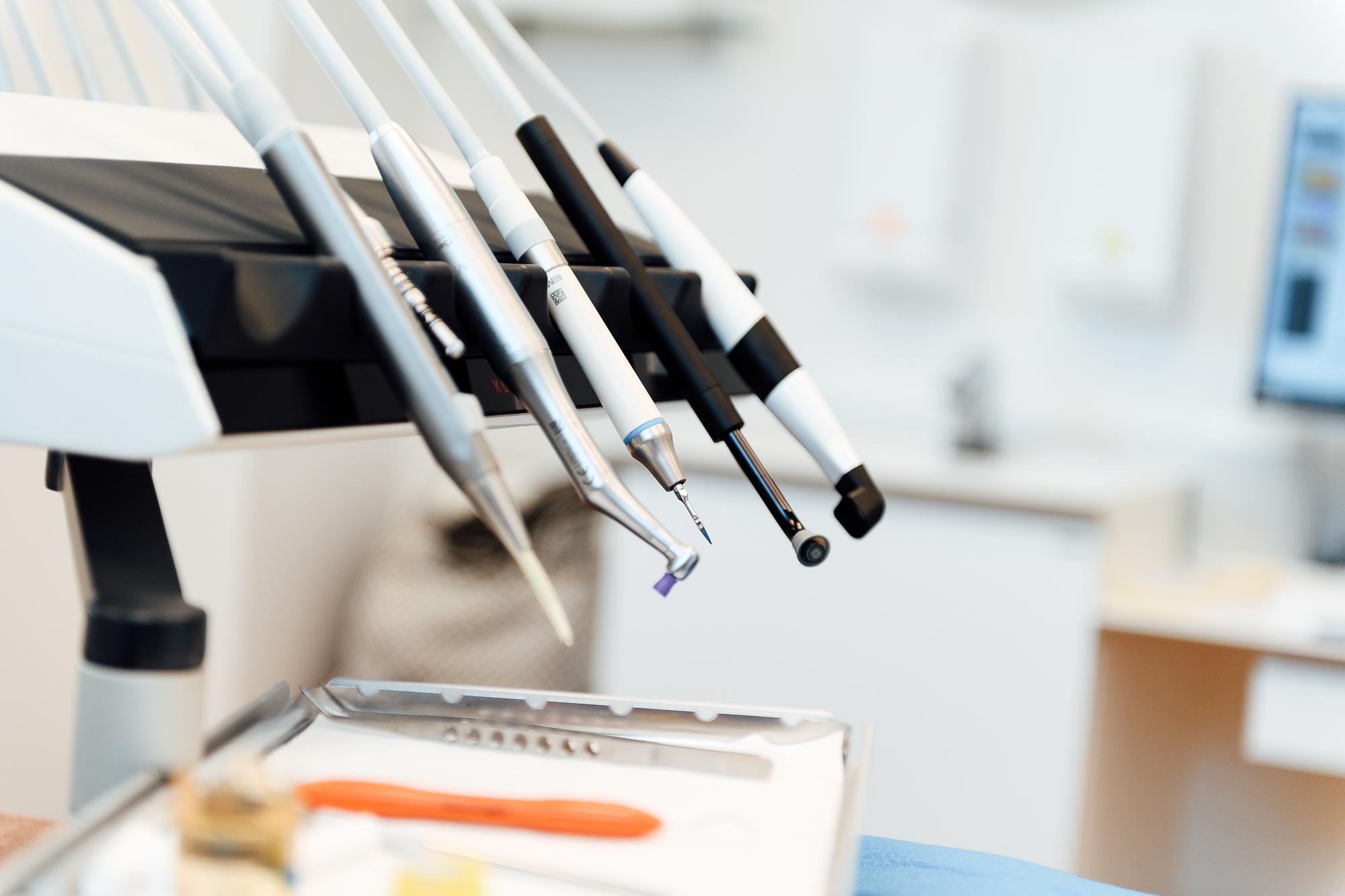 Dentalværktøjer hængende på en tandlægestol i et moderne tandlægeklinik.