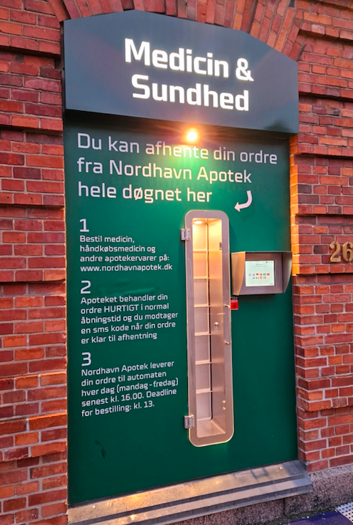Medicinsk skilt ved Nordhavn Apotek, der informerer om afhentning af medicin døgnet rundt.