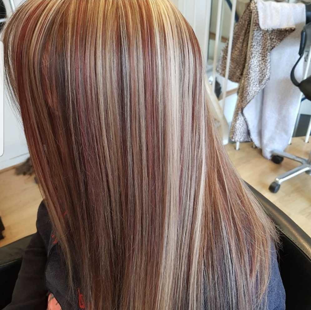 Hår med striber i rød, blond og brun farve, der falder glat ned ad ryggen.