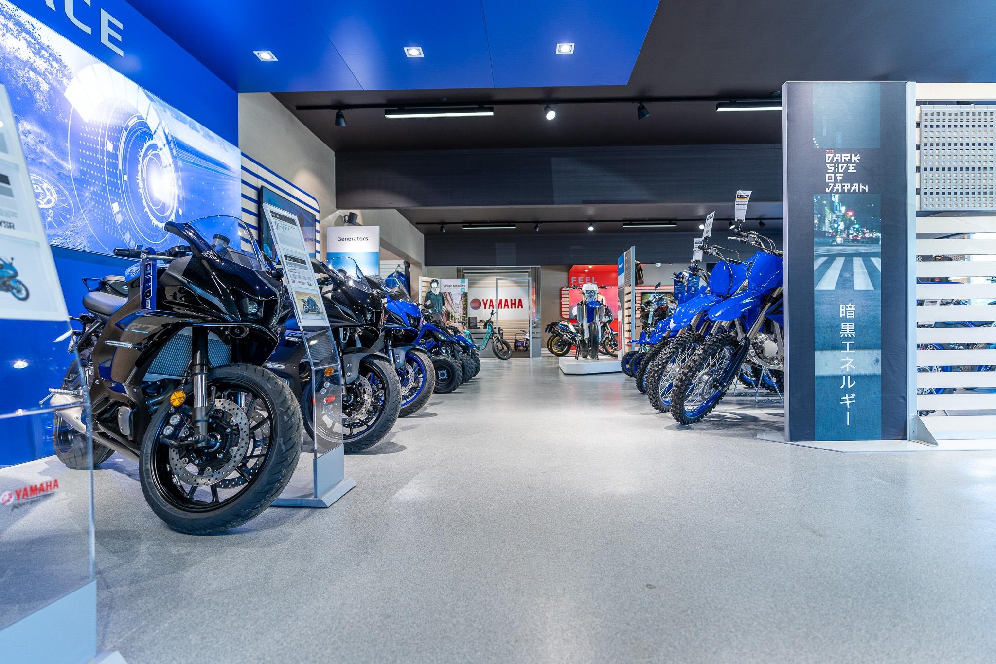 En moderne motorcykelbutik med flere motorcykler udstillet i et lyst og åbent rum.