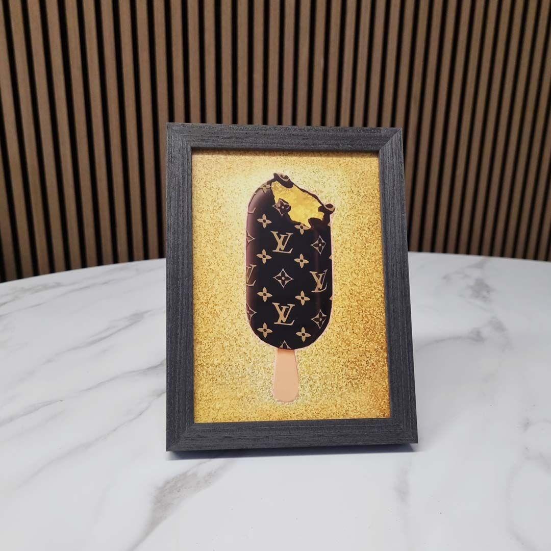 Billede af en indrammet illustration af en is med Louis Vuitton-mønster på en gylden baggrund.