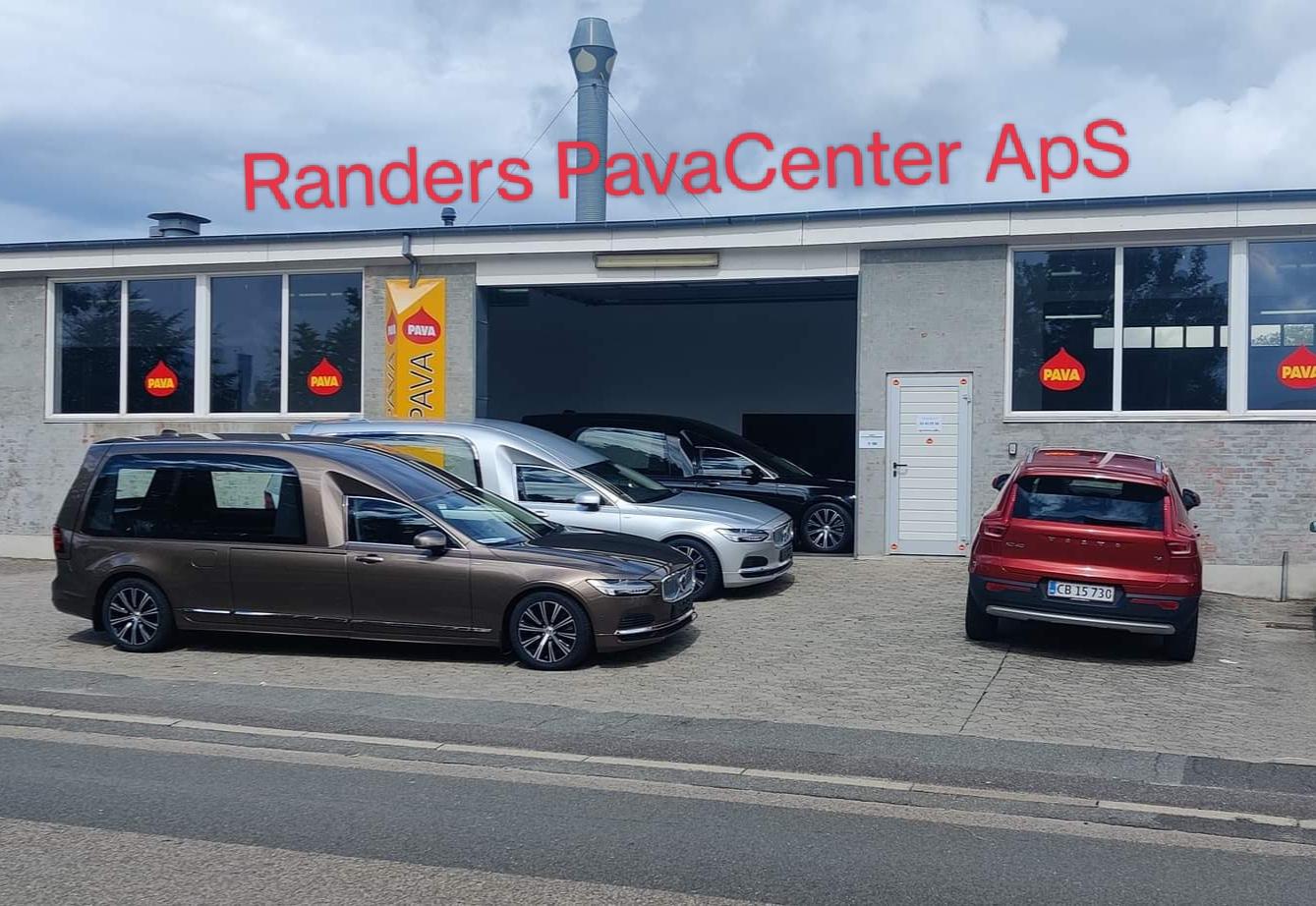 Bilforhandler med flere biler parkeret foran en garage, Randers PavaCenter ApS i baggrunden.