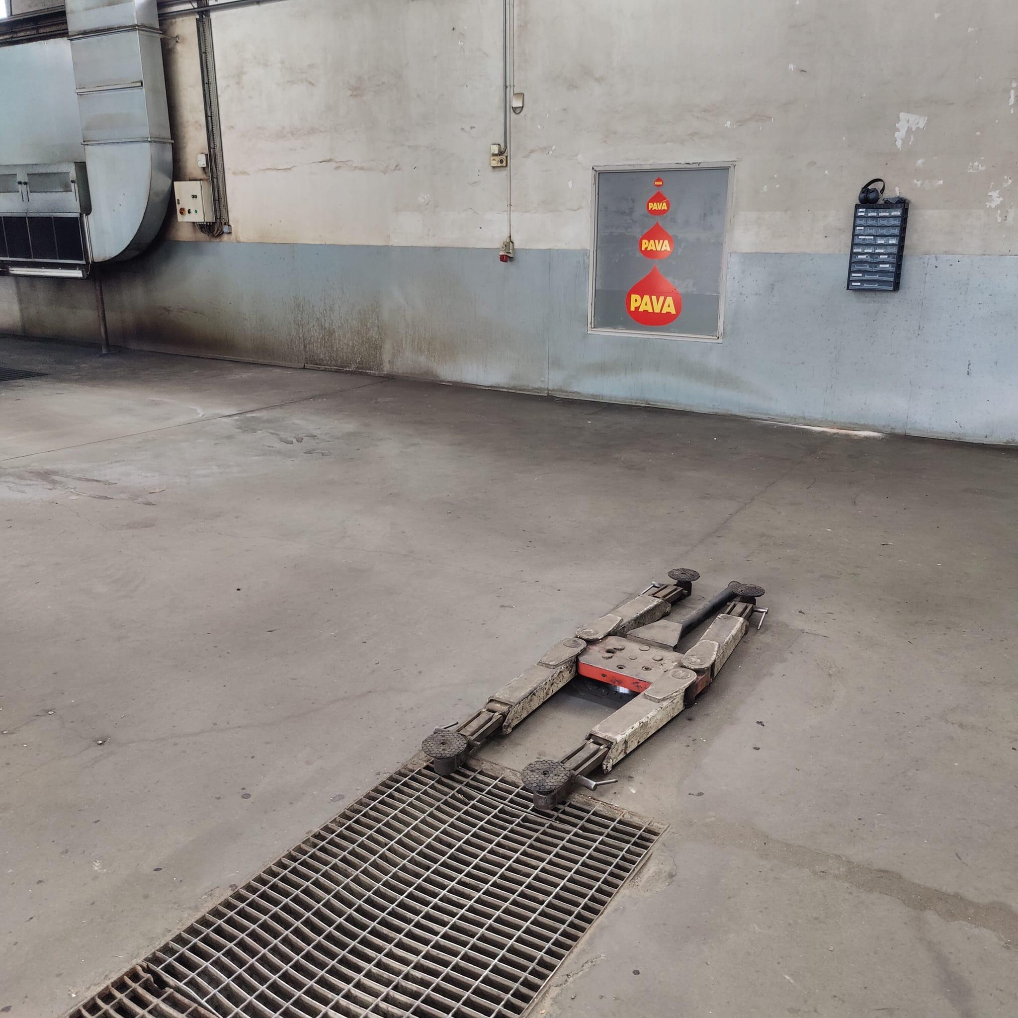 En tom garage med en metalramp og en rød PAVA-signal i baggrunden.