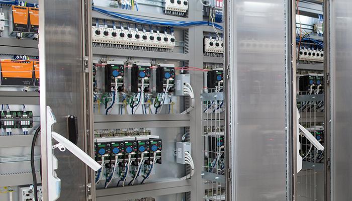 Billede af et elektrisk skab med styresystemer og kabler til industriel automation.