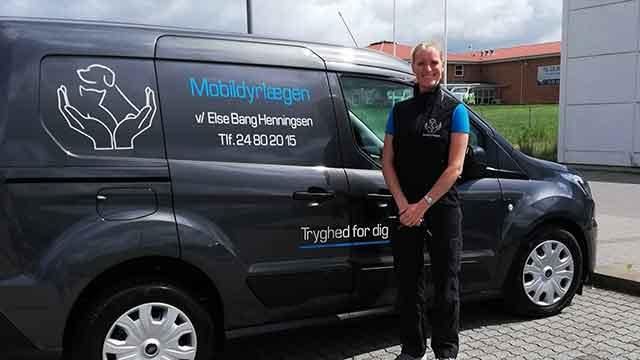 En person står ved siden af en varevogn med logoet for Mobilvagten, der tilbyder tryghed og service.