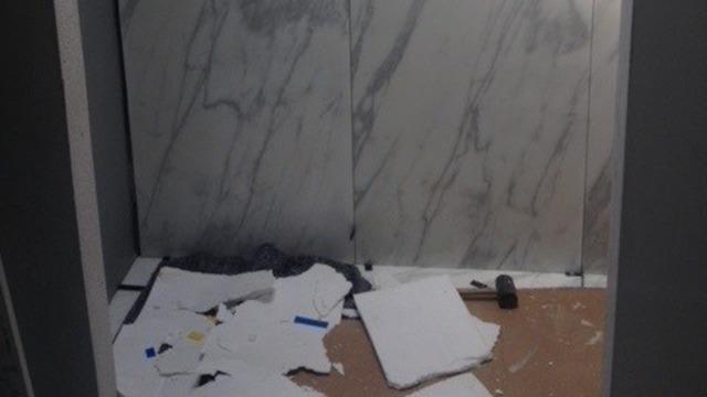Rodet rum med affald og skrot, herunder pap og byggematerialer på gulvet.
