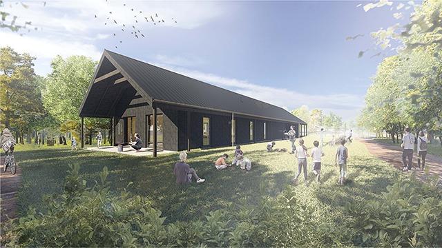 Moderne bygning med sort tag og store vinduer, omgivet af grønne træer og mennesker, der nyder naturen.