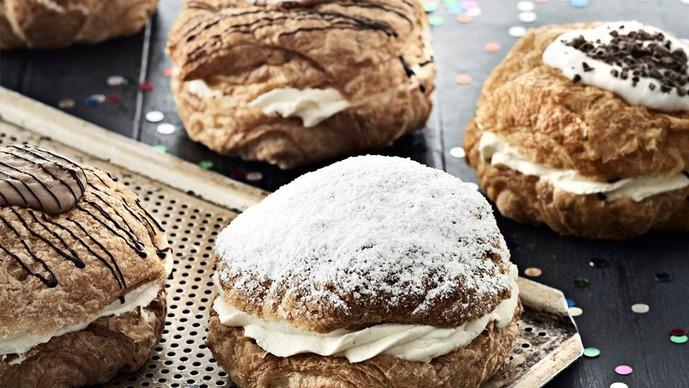 Lækre flødeboller med forskelligt fyld og pynt, præsenteret på en bageplade med farverige konfetti.