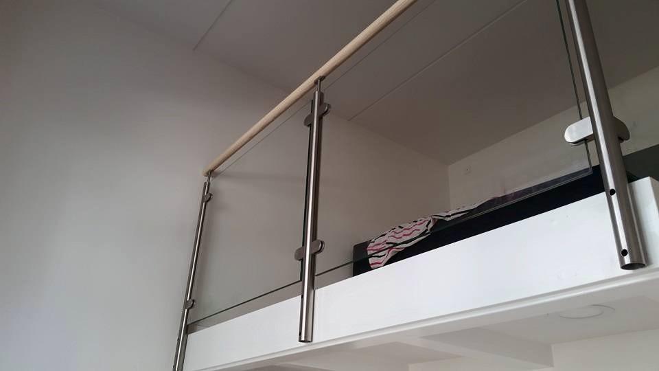 Billede af en moderne indendørs altan med glasgelænder og en seng på en hems.