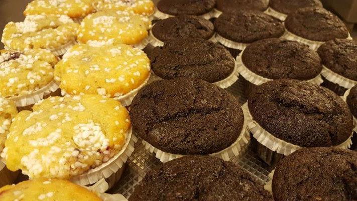 Fristende muffins i gule og mørke chokoladevarianter, præsenteret i papirforme.