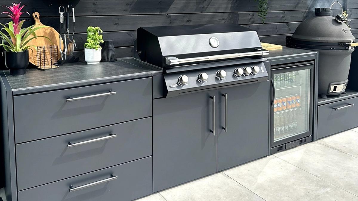 Moderne udendørs køkken med grill, køleskab og opbevaringsskabe i grå farve.