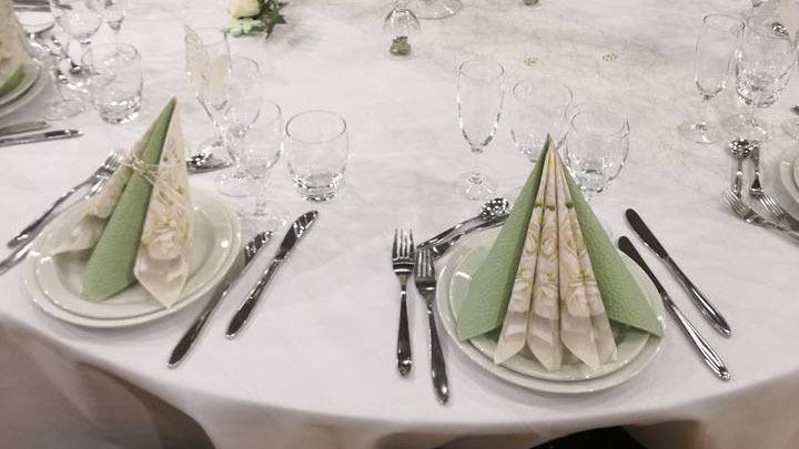 Elegant dækket bord med grønne servietter og glas til festlig lejlighed.