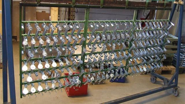 En metalramme med mange kroge til opbevaring af værktøj og udstyr i en værksted.