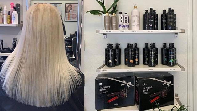 Langt, lyst hår set bagfra i en frisørsalon med hylder fyldt med hårprodukter.