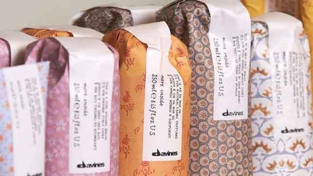 Farverige shampoo- og balsamflasker fra Davines med dekorative etiketter i forskellige mønstre.