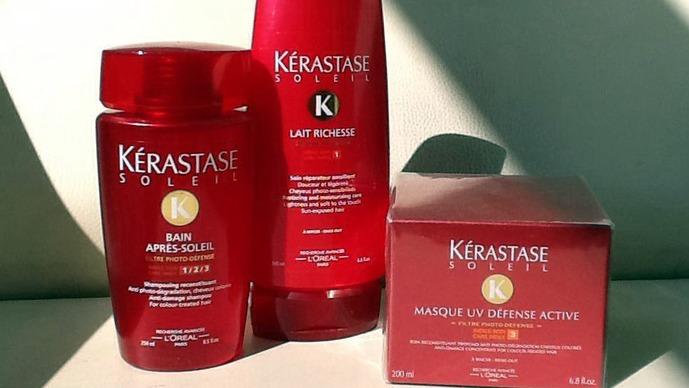 Kérastase Soleil hårplejeprodukter, herunder shampoo, balsam og maske, præsenteret i rød emballage.