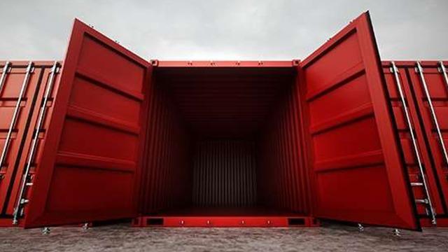 Åben rød container med åbne døre, set fra indersiden mod en grå himmel.