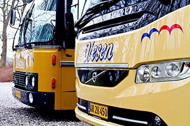 To busser parkeret side om side med tydelige logoer og nummerplader, der viser deres tilhørsforhold.