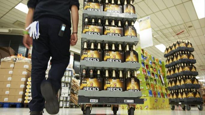 En person går forbi en vogn med Beck's øl i supermarkedet.