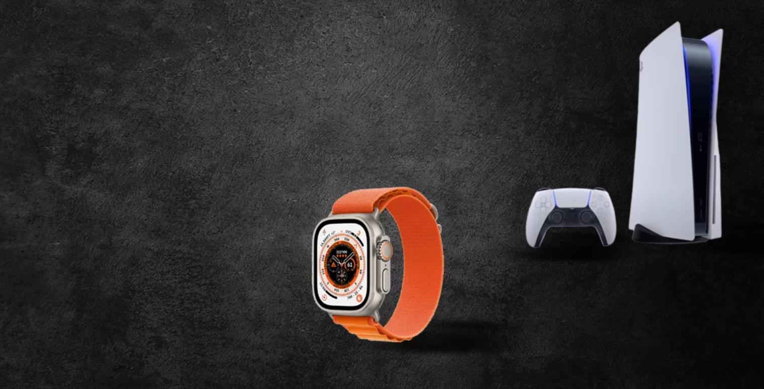 Smartwatch med orange rem, PlayStation 5 konsol og controller på en mørk baggrund.