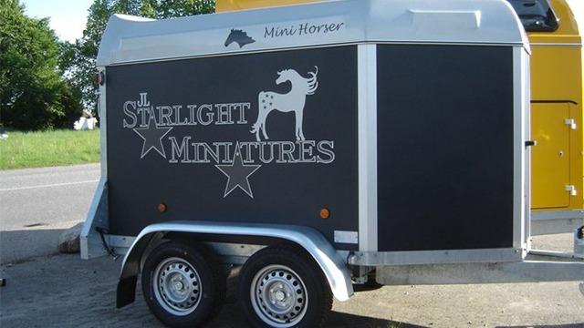 En hestetrailer med teksten "Starlight Miniatures" og et billede af en hjort på siden.
