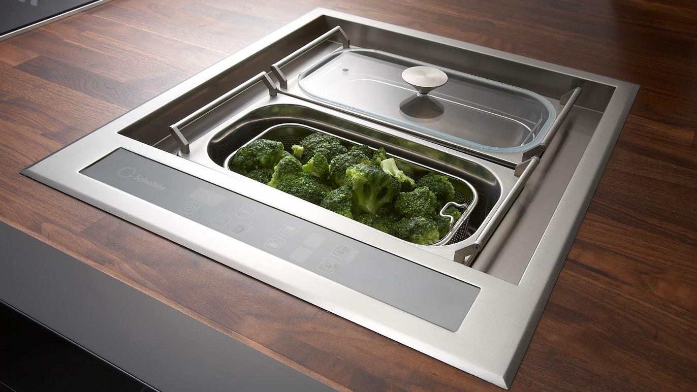 Køkkenbord med indbygget grøntsagsbeholder, der indeholder friske broccoli.