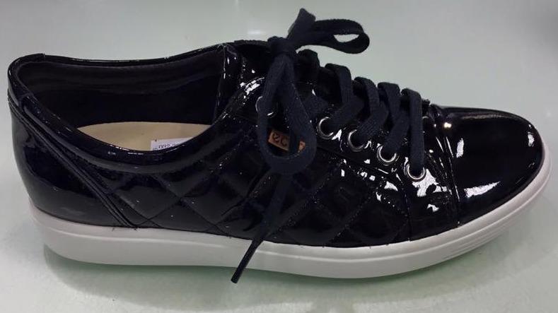 Sorte blanke sneakers med snørebånd og quiltet mønster på siden.