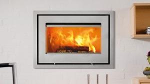 Moderne pejs med flammer og brænde, indbygget i en væg med minimalistisk design.