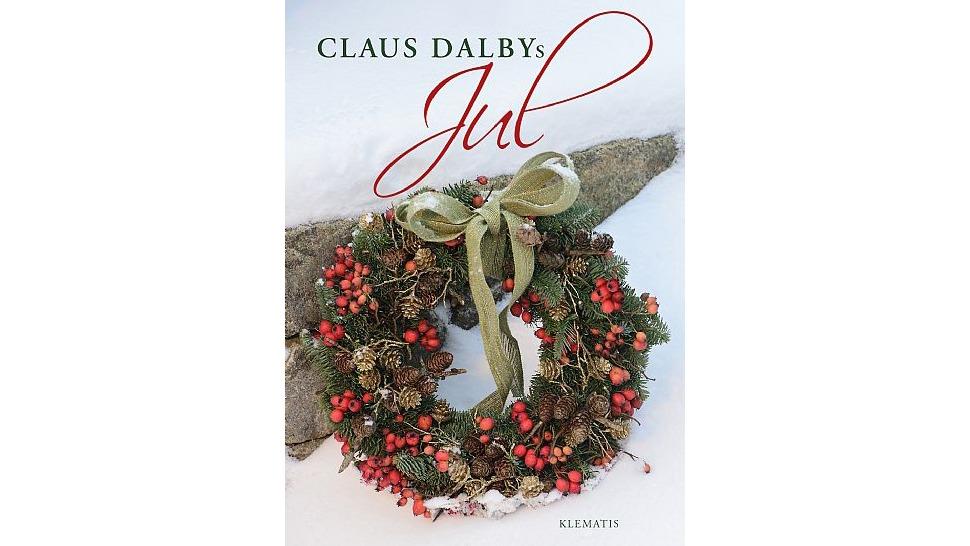En smuk julekrans med gran, bær og en grøn sløjfe, prydet med teksten "Claus Dalbys Jul".