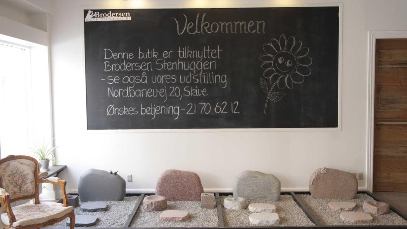 Væg med velkomstskilt og sten til fodbad i en afslappende atmosfære i en wellness-lokale.
