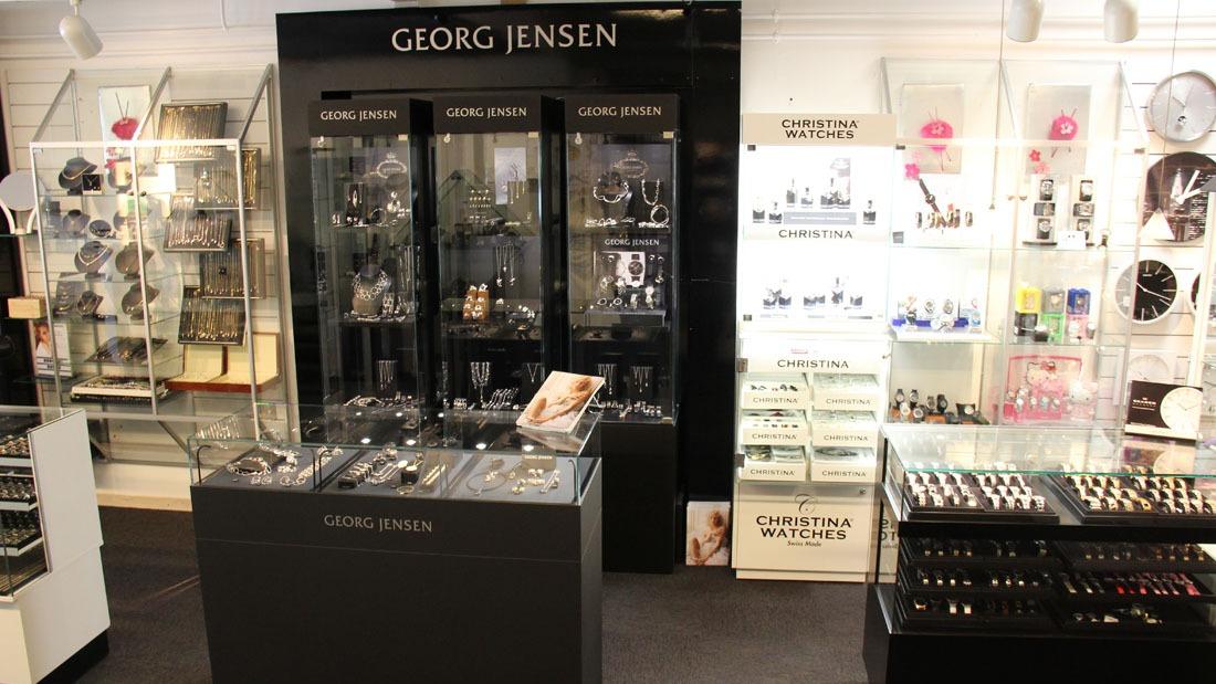 Butik med Georg Jensen smykker og tilbehør, herunder udstillingsskabe og smykker på hylder.