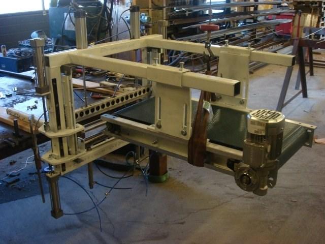 En industriel maskine med metalramme og motor, der bruges til præcisionsarbejde i et værksted.