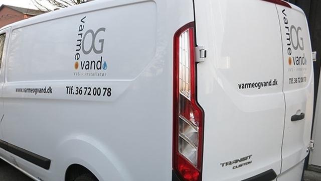 En hvid varevogn med logoet "varme og vand" og kontaktinformation på bagsiden.