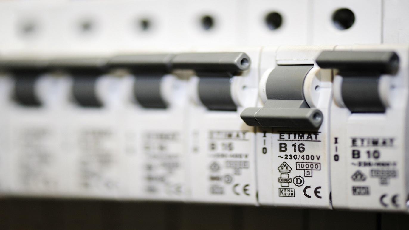 Nærbillede af elektriske sikringer med mærkning og spænding, installeret i en el-tavle.