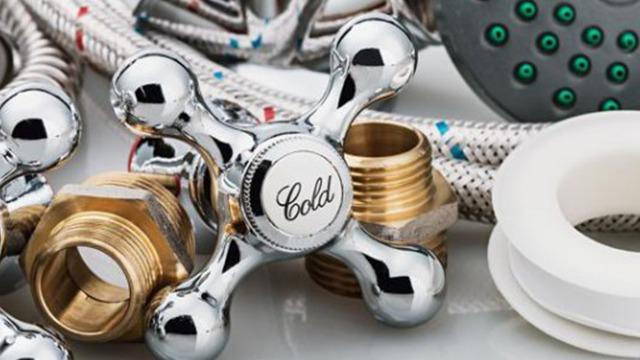 Krom vandhane med "Cold" mærkning, metalrør og tilbehør til VVS-installation.