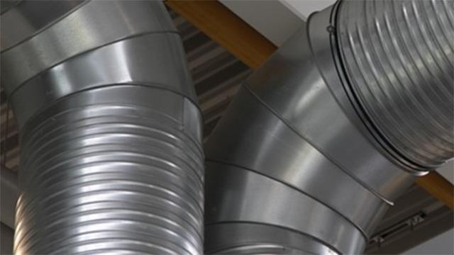 Metalrør til ventilation, der er bøjet og sammenkoblet i et moderne byggeri.