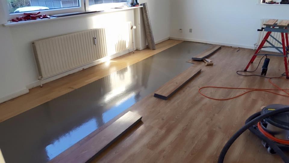 Gulvbelægning i et rum med træplanker og værktøj til installation af laminatgulv.