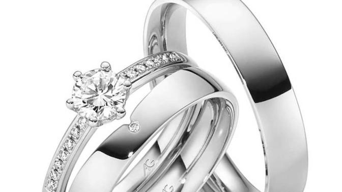 Tre smukke ringe i hvidguld, herunder en forlovelsesring med en stor diamant og små diamanter.