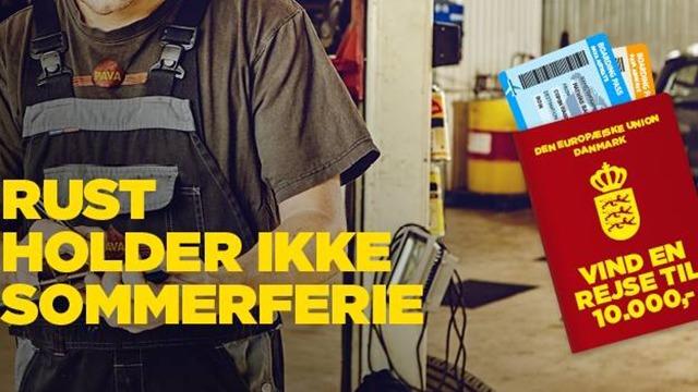 En mekaniker holder en værktøjskasse med en plakat om sommerferie og en konkurrence om en rejse til 10.000 kr.