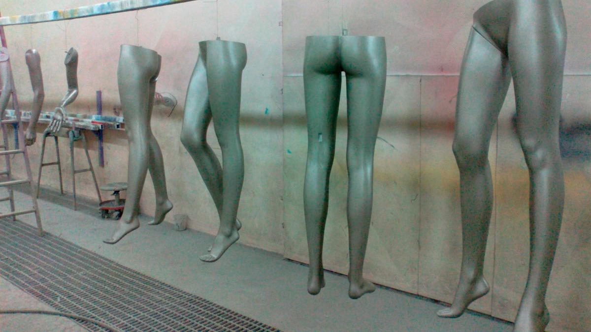 Mannequiner med malede ben står oprejst i et værksted, klar til at blive dekoreret.