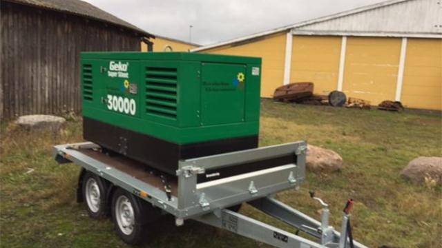 Generator på en trailer, klar til transport, med en grøn kasse og nummeret 30000 synligt.